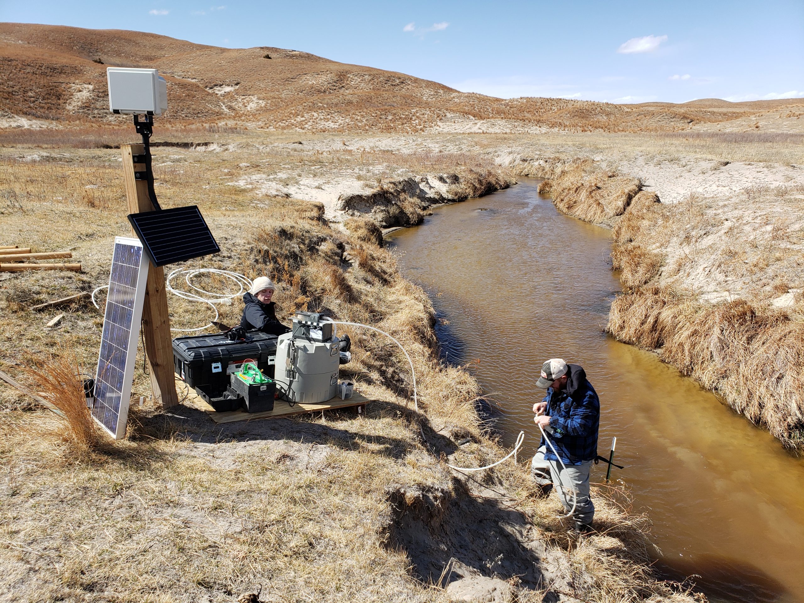 Scientists setting up monitoring equipment on a groundwater-fed Sandhills stream in Nebraska